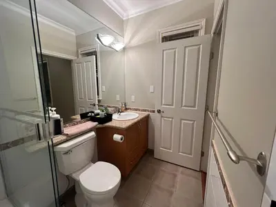 a bathroom with a toilet and a sink and a mirror at A cozy independent entrance bedroom with a private washroom close to YVR Richmond in Richmond