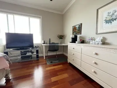 a living room with a television and a dresser at A cozy independent entrance bedroom with a private washroom close to YVR Richmond in Richmond
