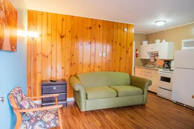 a living room with a couch and a kitchen at Lakeview Motel in Christina Lake