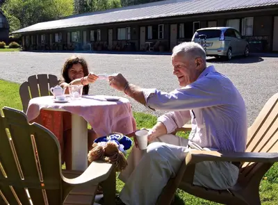 an older man sitting at a table feeding a woman at Lakeview Motel in Christina Lake