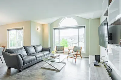 a living room with a couch and a table at Cozy 5BD House in North Mission Crawford in Kelowna