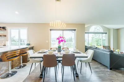a kitchen and dining room with a table and chairs at Cozy 5BD House in North Mission Crawford in Kelowna