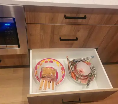a drawer with plates and utensils in a kitchen at Welcome to Happy Place where Cozy Comfort Meets Exquisite Luxury in Edmonton