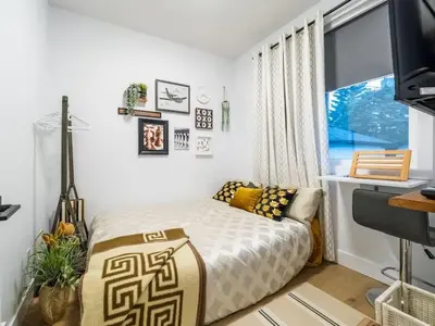 a small bedroom with a bed and a window at Welcome to Happy Place where Cozy Comfort Meets Exquisite Luxury in Edmonton