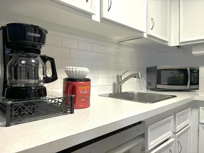 a kitchen counter with a coffee maker and a sink at Roomy Top Floor at Stampede w Free Parking and AC in Calgary
