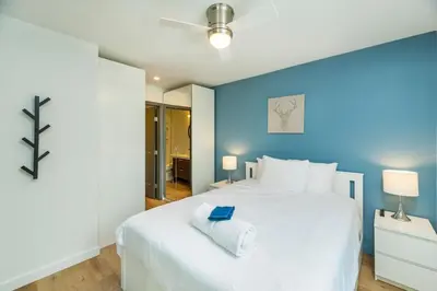 a bedroom with a white bed with a blue wall at NN War Eagles Nest Ravens Ridge 1bed 1 bath in Whitehorse