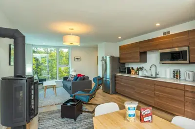 a kitchen and a living room with a couch and a table at NN War Eagles Nest Ravens Ridge 1bed 1 bath in Whitehorse