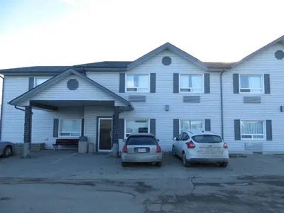 two cars parked in front of a house at Crossfield Country Inn in Crossfield