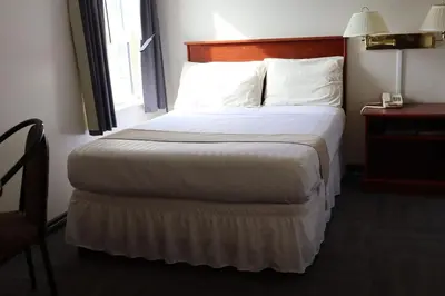 a hotel room with a bed and a window at Destination Family Hotel in Whitehorse