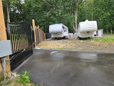 two rvs parked in a lot next to a fence at Comfortable RV in a farm in Nanoose Bay