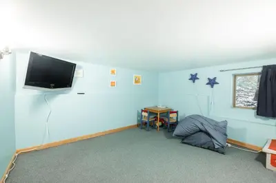 a room with a blue wall with a flat screen tv at Forest Trails by Outpost Whistler in Whistler
