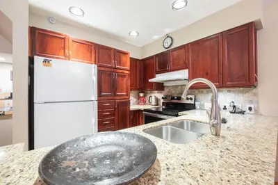a kitchen with a sink and a white refrigerator at Forest Trails by Outpost Whistler in Whistler