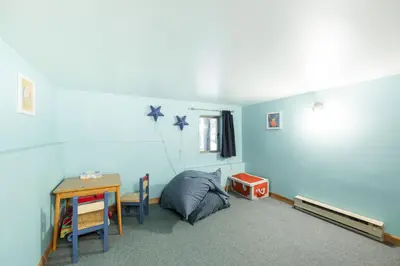 a bedroom with a bed and a desk and a table at Forest Trails by Outpost Whistler in Whistler