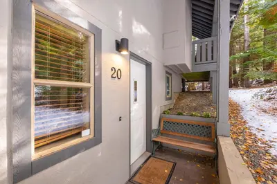 a house with a door with a window and a bench at Forest Trails by Outpost Whistler in Whistler