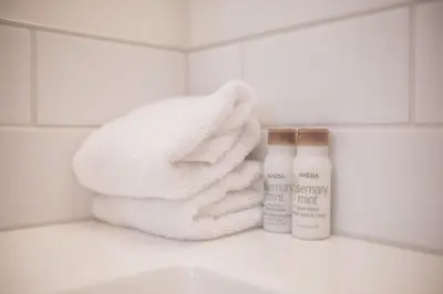 a pile of towels and a bottle of lotion in a bathroom at Powderview by Outpost Whistler in Whistler