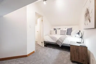 a bedroom with a bed with white sheets and blue pillows at Powderview by Outpost Whistler in Whistler