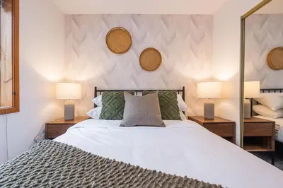 a bedroom with a bed with two lamps and a mirror at Powderview by Outpost Whistler in Whistler