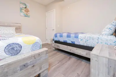 a bedroom with two beds and a wooden table at Cozy Springs in Calgary