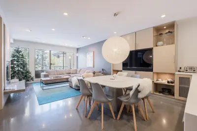 a kitchen and living room with a table and chairs at Gleneagles by Outpost Whistler in Whistler