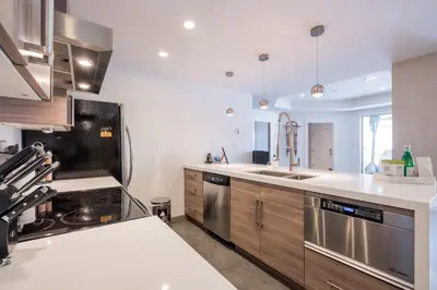 a kitchen with wooden cabinets and stainless steel appliances at Gleneagles by Outpost Whistler in Whistler
