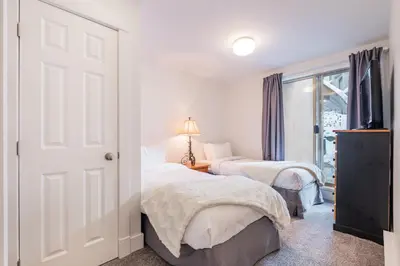 a bedroom with two beds and a window at Gleneagles by Outpost Whistler in Whistler