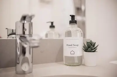 a bottle of hand soap sitting on a bathroom sink at Lake Placid Lodge by Outpost Whistler in Whistler