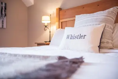 a bed with a pillow with the word whistler on it at Mountain Star by Outpost Whistler in Whistler