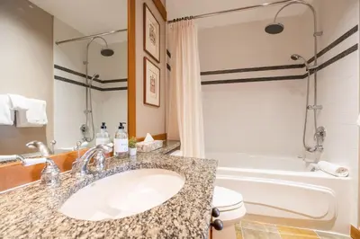 a bathroom with a sink and a tub and a toilet at Mountain Star by Outpost Whistler in Whistler
