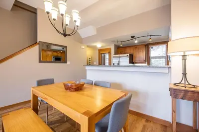 a dining room and kitchen with a wooden table and chairs at Mountain Star by Outpost Whistler in Whistler