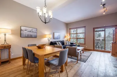 a living room with a wooden table and chairs at Mountain Star by Outpost Whistler in Whistler