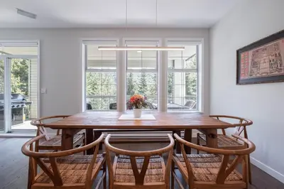 a dining room with a wooden table and chairs at Lynx by Outpost Whistler in Whistler