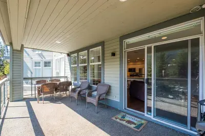 a screened in porch with chairs and a table at Lynx by Outpost Whistler in Whistler