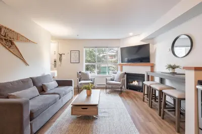 a living room with a couch and a fireplace at Glacier's Reach by Outpost Whistler in Whistler