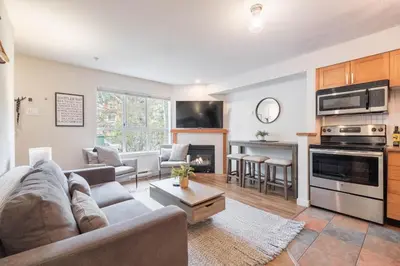 a living room with a couch and a fireplace at Glacier's Reach by Outpost Whistler in Whistler