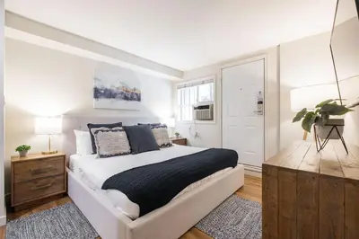a white bedroom with a bed and a window at Glacier's Reach by Outpost Whistler in Whistler