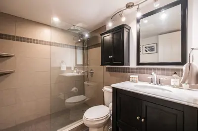 a bathroom with a toilet and a sink and a mirror at Glacier's Reach by Outpost Whistler in Whistler