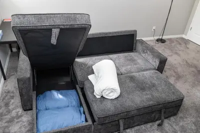 a couch with a white pillow on top of it at The Jade Place in Airdrie