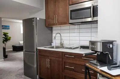 a kitchen with a stainless steel refrigerator and a sink at The Jade Place in Airdrie
