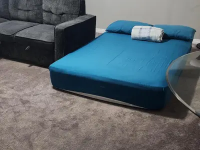 a blue ottoman next to a couch and a glass table at The Jade Place in Airdrie