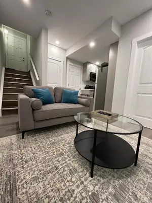 a living room with a couch and a glass table at Private Chic Modern Suite with Kitchen near Spruce Meadows and LRT in Calgary