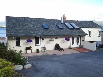 a white house with solar panels on the roof at Casa Loma BnB in West Kelowna