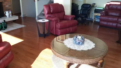 a living room with a table and a couch and chairs at Casa Loma BnB in West Kelowna