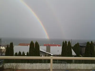 a rainbow in the sky over a city at Casa Loma BnB in West Kelowna