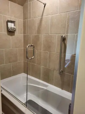 a shower with a glass door next to a tub at Casa Loma BnB in West Kelowna