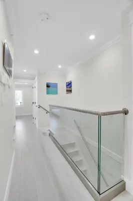 a glass staircase in a white room with white walls at Family-Friendly, 3 Bed House - Private Backyard-Central Location in Vancouver