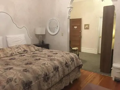 a bedroom with a bed and a mirror on the wall at Haterleigh Heritage Inn in Victoria