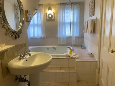 a bathroom with a sink and a bath tub at Haterleigh Heritage Inn in Victoria