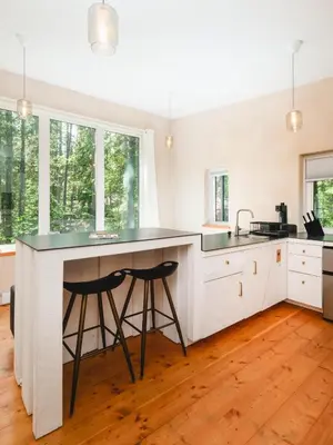 a kitchen with a large island with two bar stools at Black Spruce - Orange Door in Whitehorse