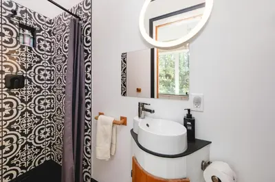 a bathroom with a sink and a mirror at Black Spruce - Orange Door in Whitehorse
