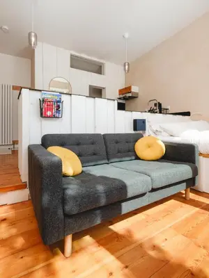 a living room with a couch and a bed at Black Spruce - Yellow Door in Whitehorse